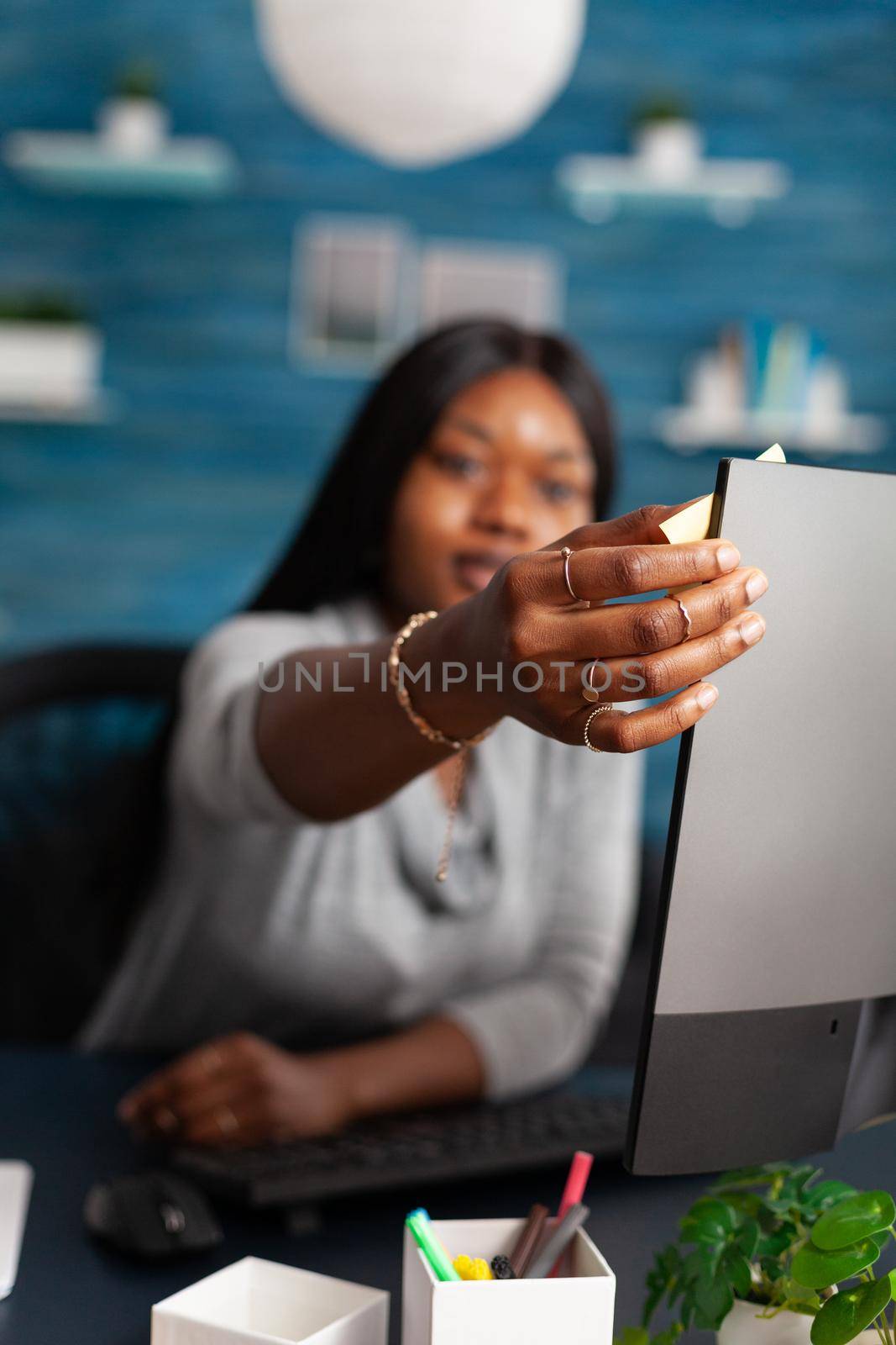Student with dark skin putting stickey notes on computer studying communication lesson by DCStudio