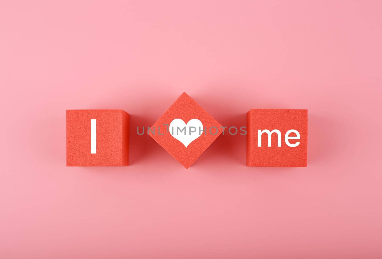 Minimal trendy concept of mental health and self love and acceptance. I love me written on red toy blocks in a row against bright pink background