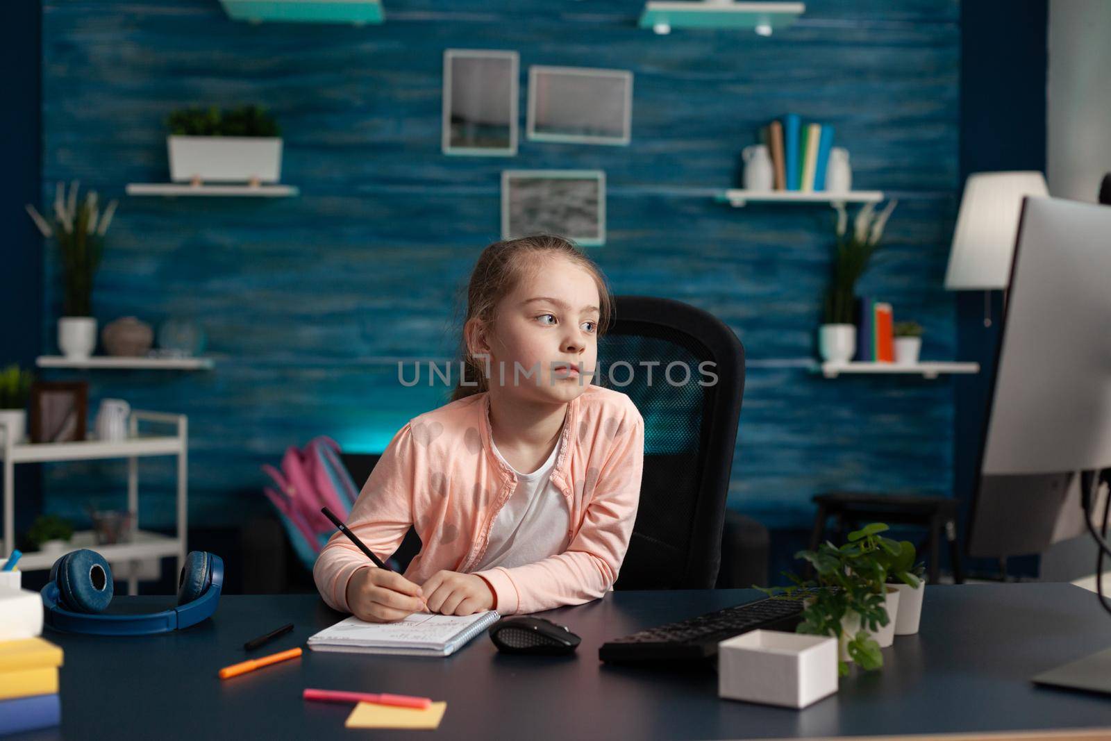 Little kid taking notes on class notebook for learning by DCStudio