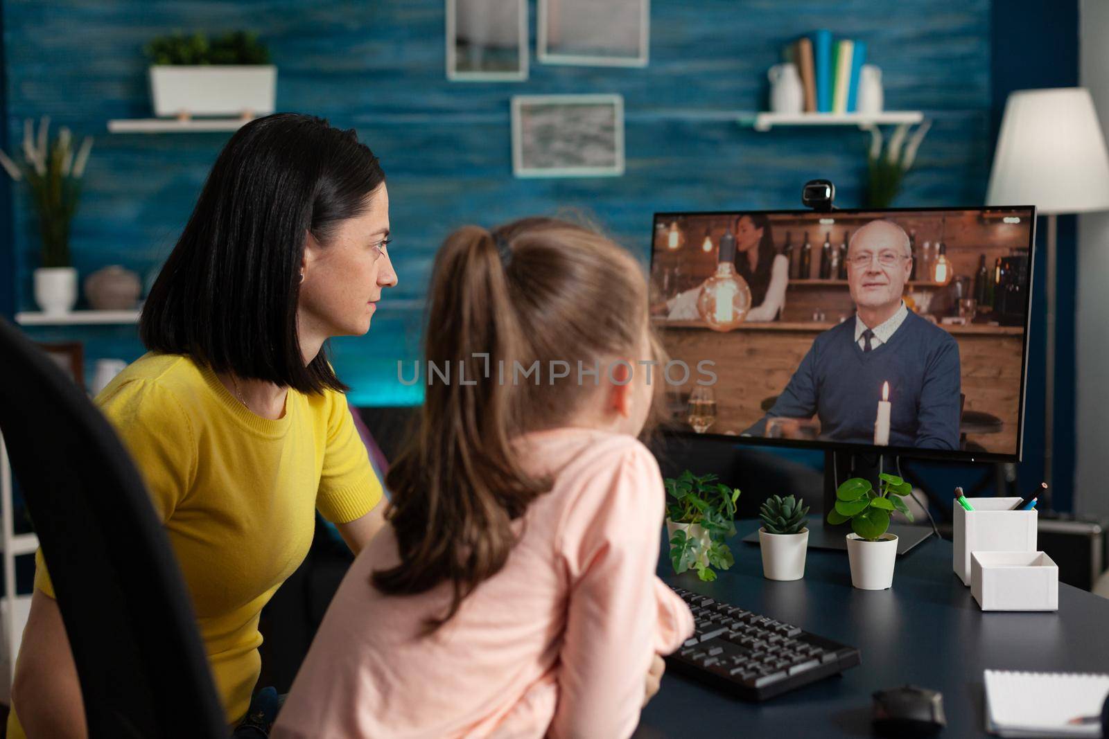 Mother and toddler using internet for video call online virtual conference modern technology. Family of adult and little girl talking to grandfather on website app meeting for communication