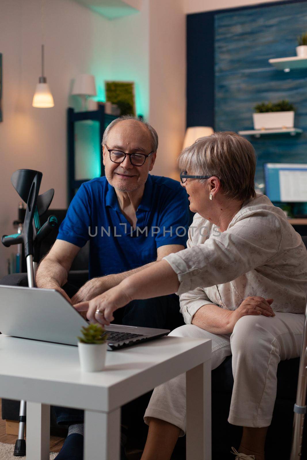 Gray haired woman old man analyzing laptop screen by DCStudio