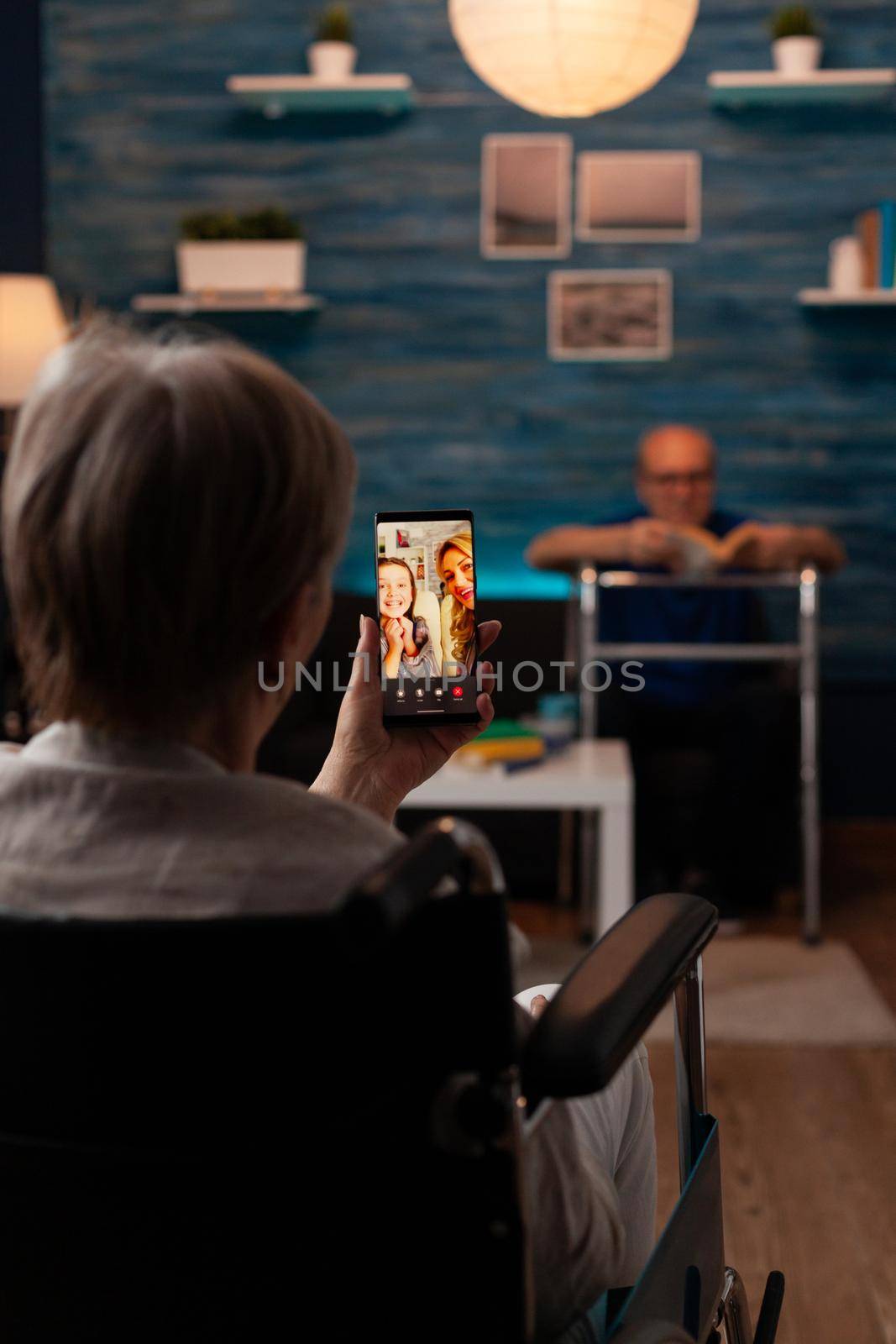 Disabled woman in wheelchair using video call technology by DCStudio