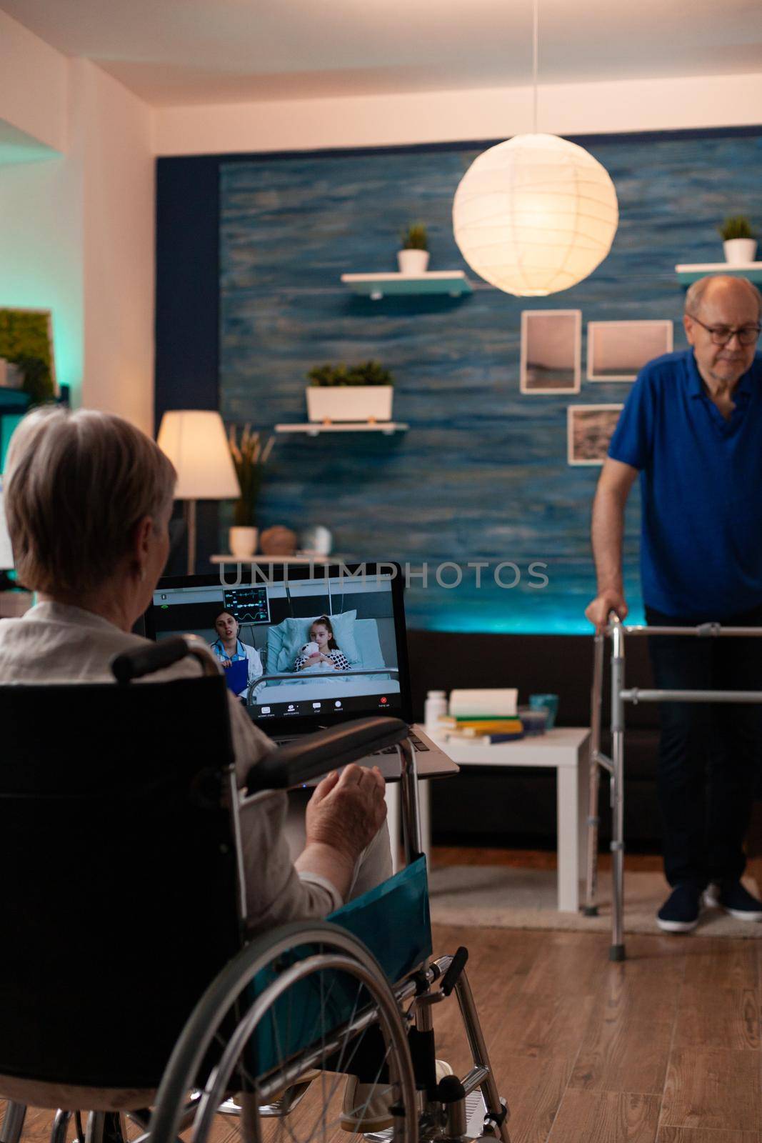 Senior woman in wheelchair using video call technology by DCStudio