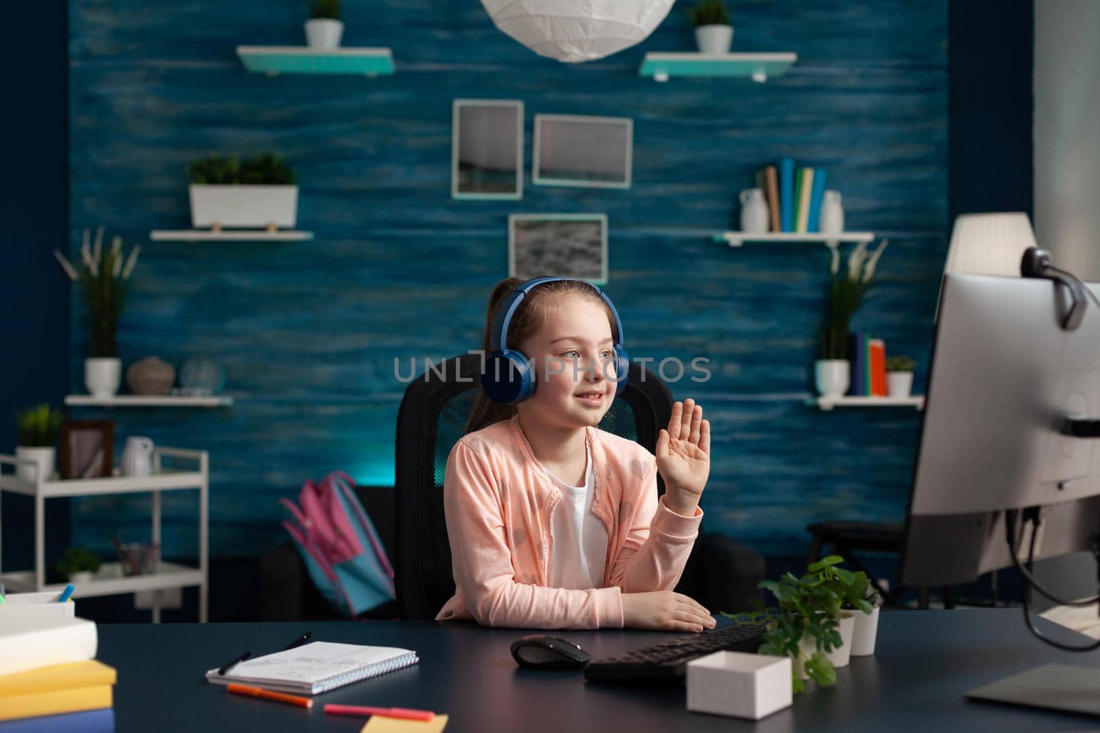 Little student waving at video call conference by DCStudio