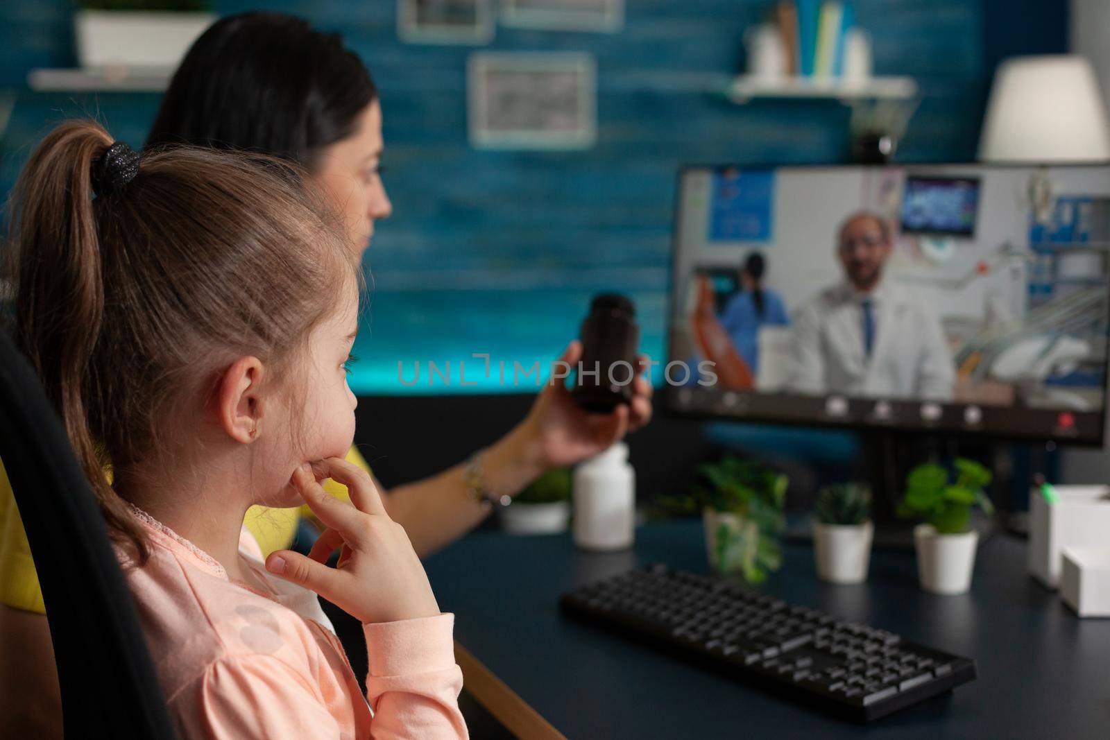 Concerned mother talking to doctor on video call conference technology about child healthcare problems. Caucasian adult using telemedicine for healing treatment diagnosis and pills