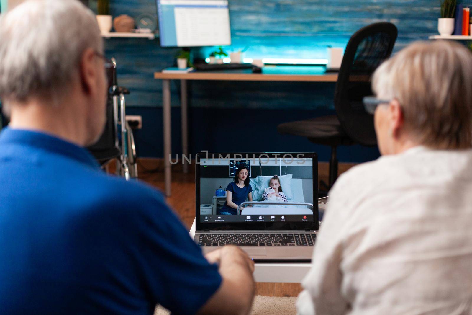 Worried grandparents on video call chat with family sick in hospital for healthcare. Elder couple using online conference internet to check up healing treatment progress for little girl