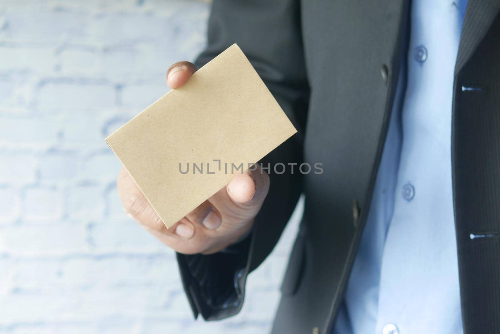 Closeup of blank business note card on man's hand.