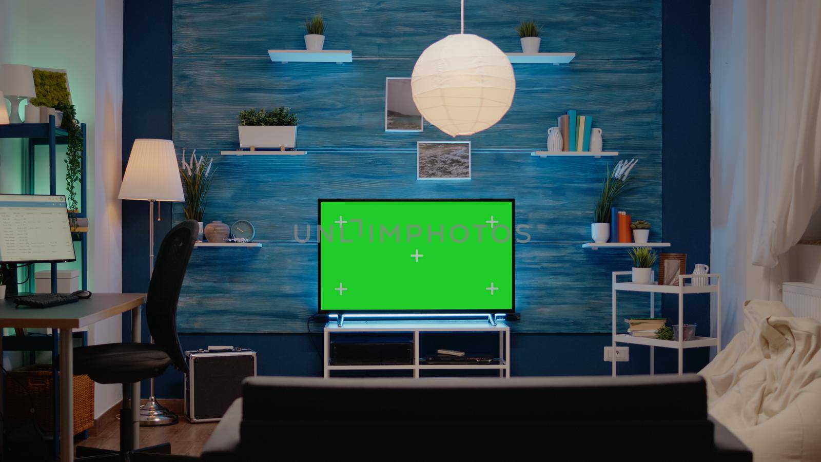 Empty modern room designed with green screen on tv at home. Nobody in area with digital technology and chroma key for isolated mockup display with copy space background and equipment