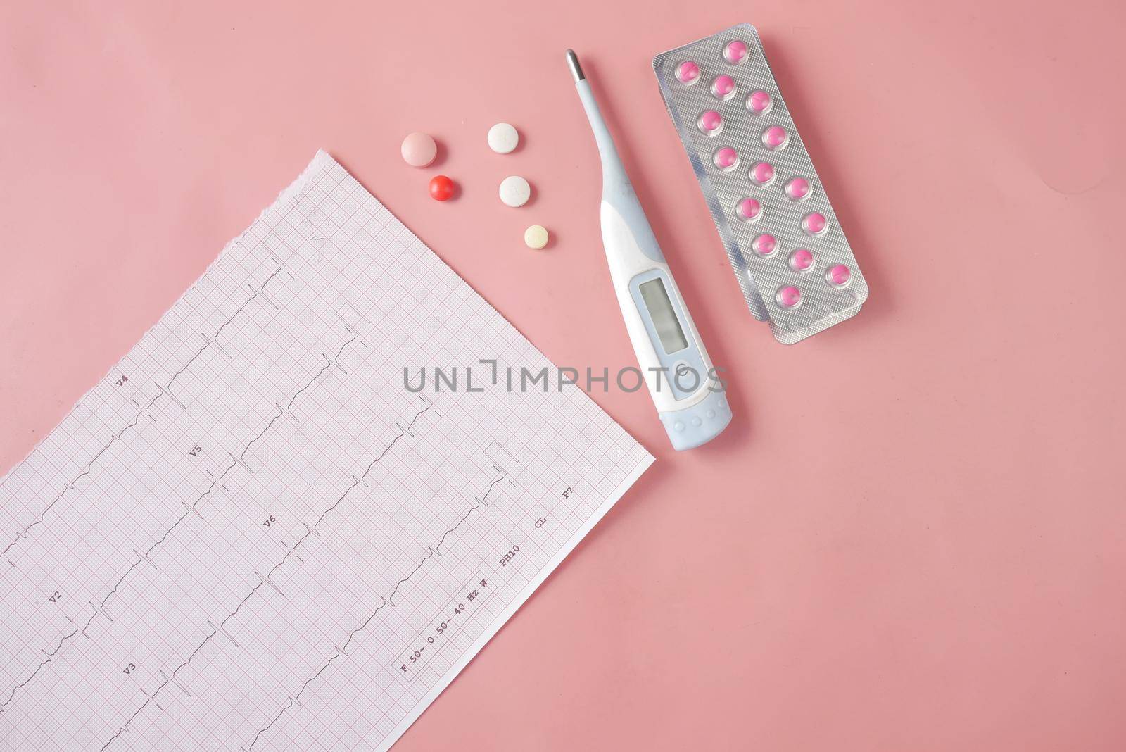 cardio diagram and medical pills on pink .