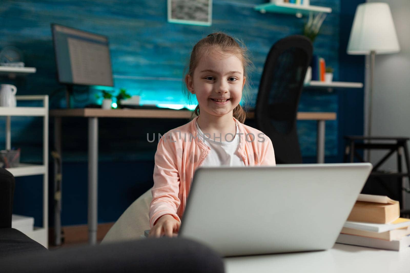 Smart little child typing on modern laptop at home desk using internet online for class lesson lecture. Caucasian girl learning primary schoolwork knowledge while social distancing