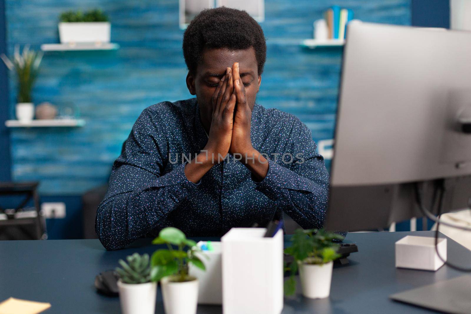 Sick african american guy stressing about deadline project having big headache. Exhausted black man worrying about business while working from home in cozy flat. Tired overwhelmed person