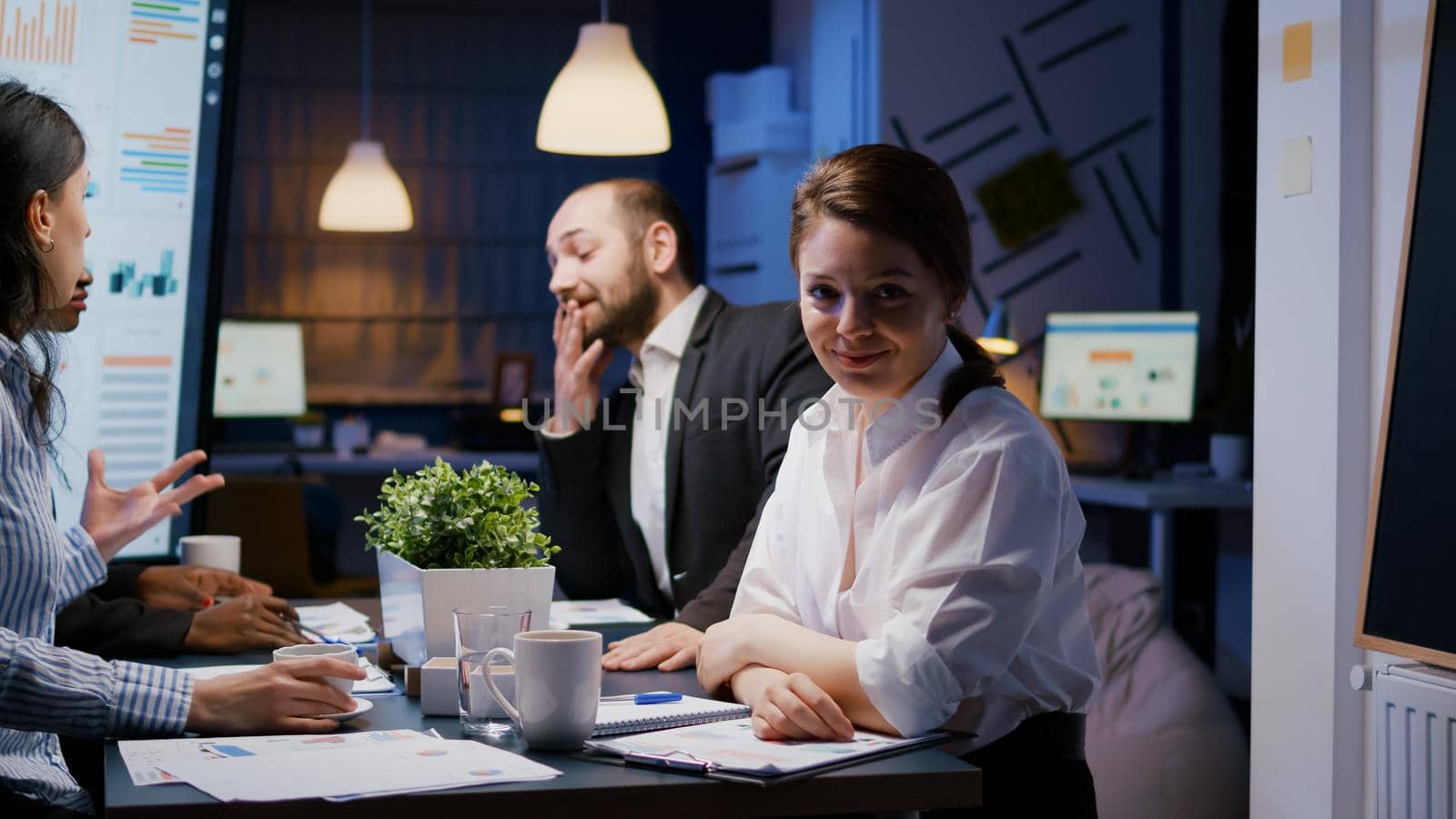 Portrait of workaholic businesswoman looking into camera while working in company office meeting room by DCStudio