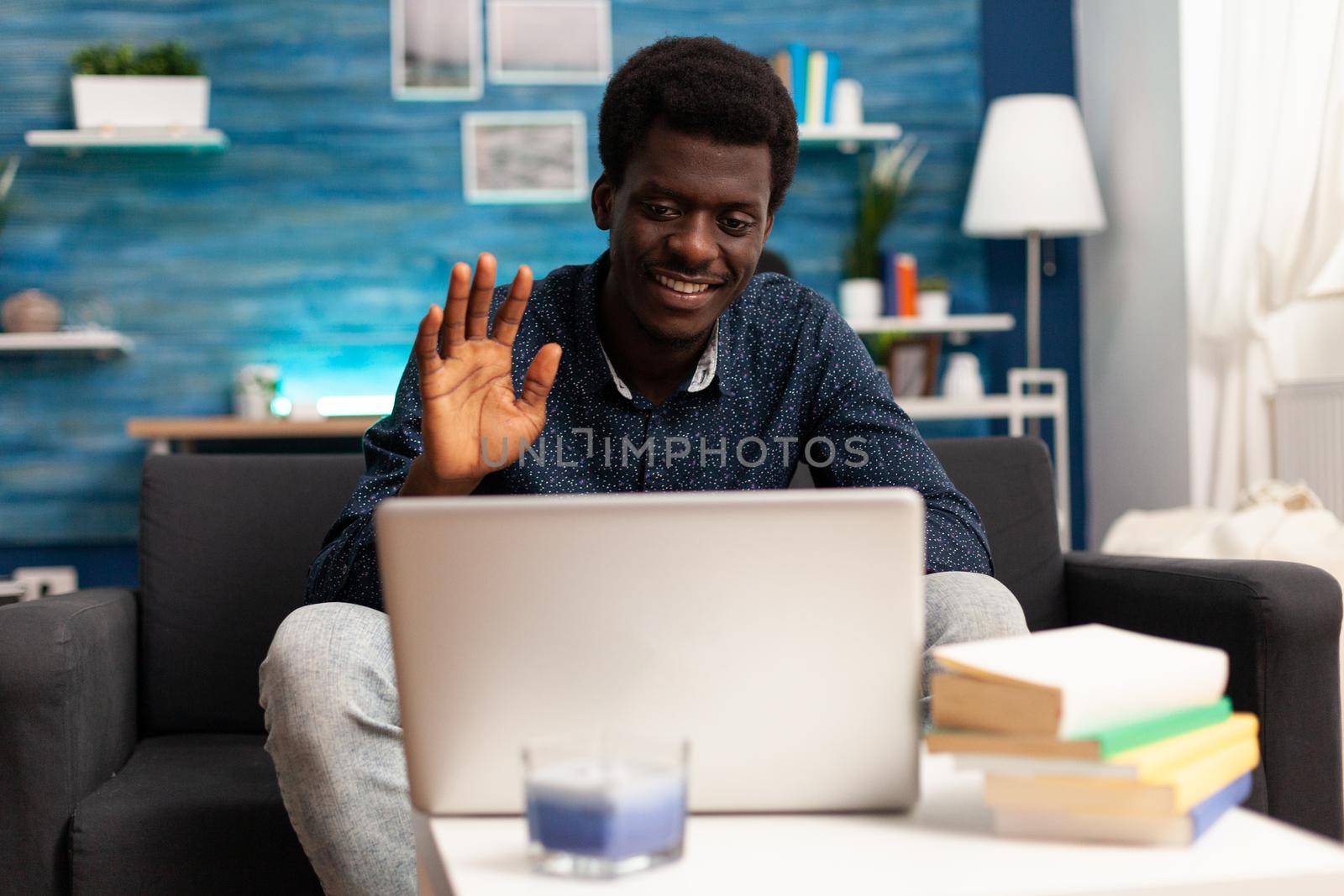 African american entrepreneur on remote video call from his living room, talking to workmates using online internet conference communication technology. Black working from home person