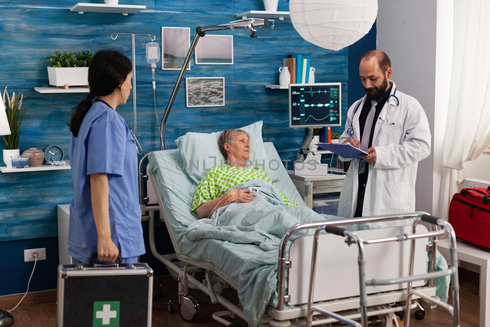 Caregiver nurse man writing medication treatment on clipboard discussing healthcare assistance. Senior woman resting in bed during Social services nursing elderly retired female. Support assistance