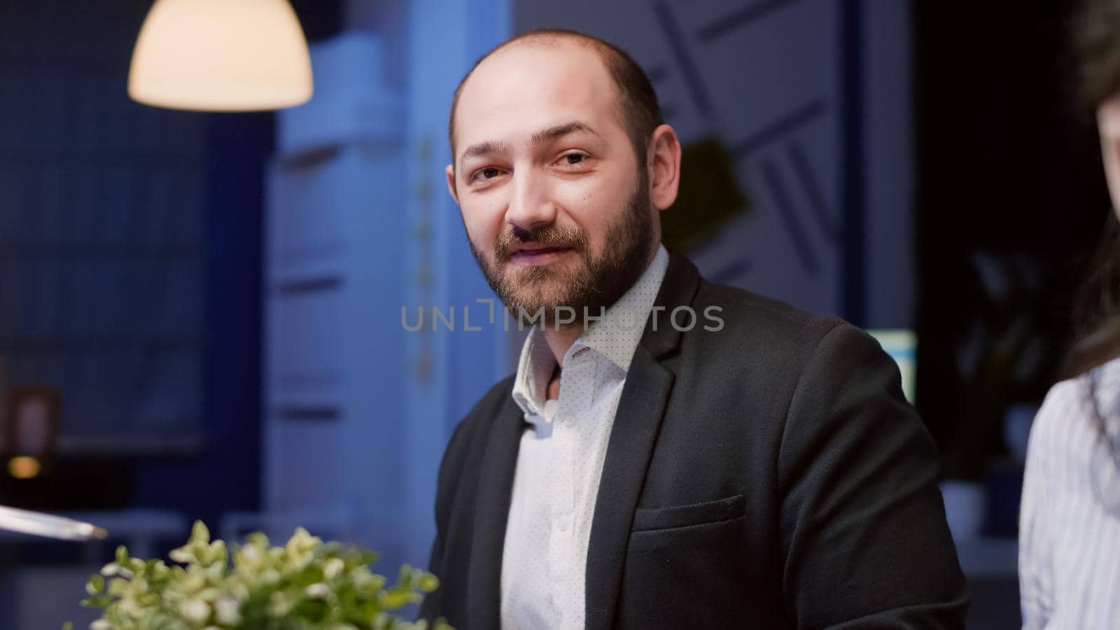 Portrait of businessman looking into camera sitting at conference table working in meeting room by DCStudio