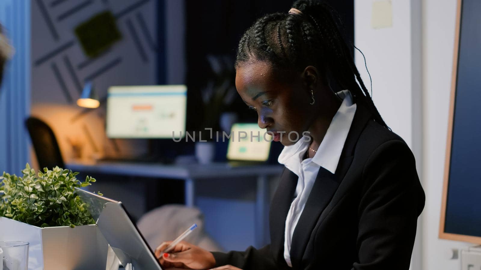 African american businesswoman writing company statistics on notebook by DCStudio