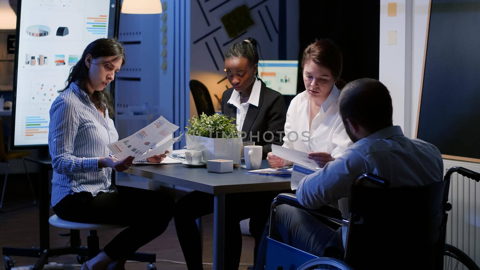 Selective focus of handicapped manager in wheelchair discussing management statistics by DCStudio