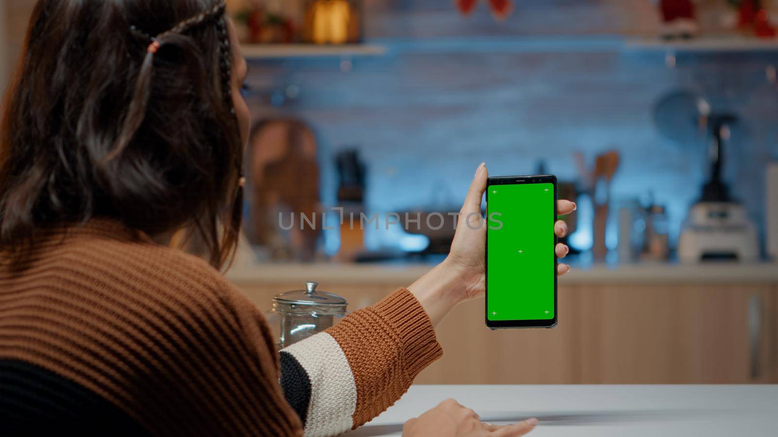 Caucasian woman holding smartphone with green screen by DCStudio