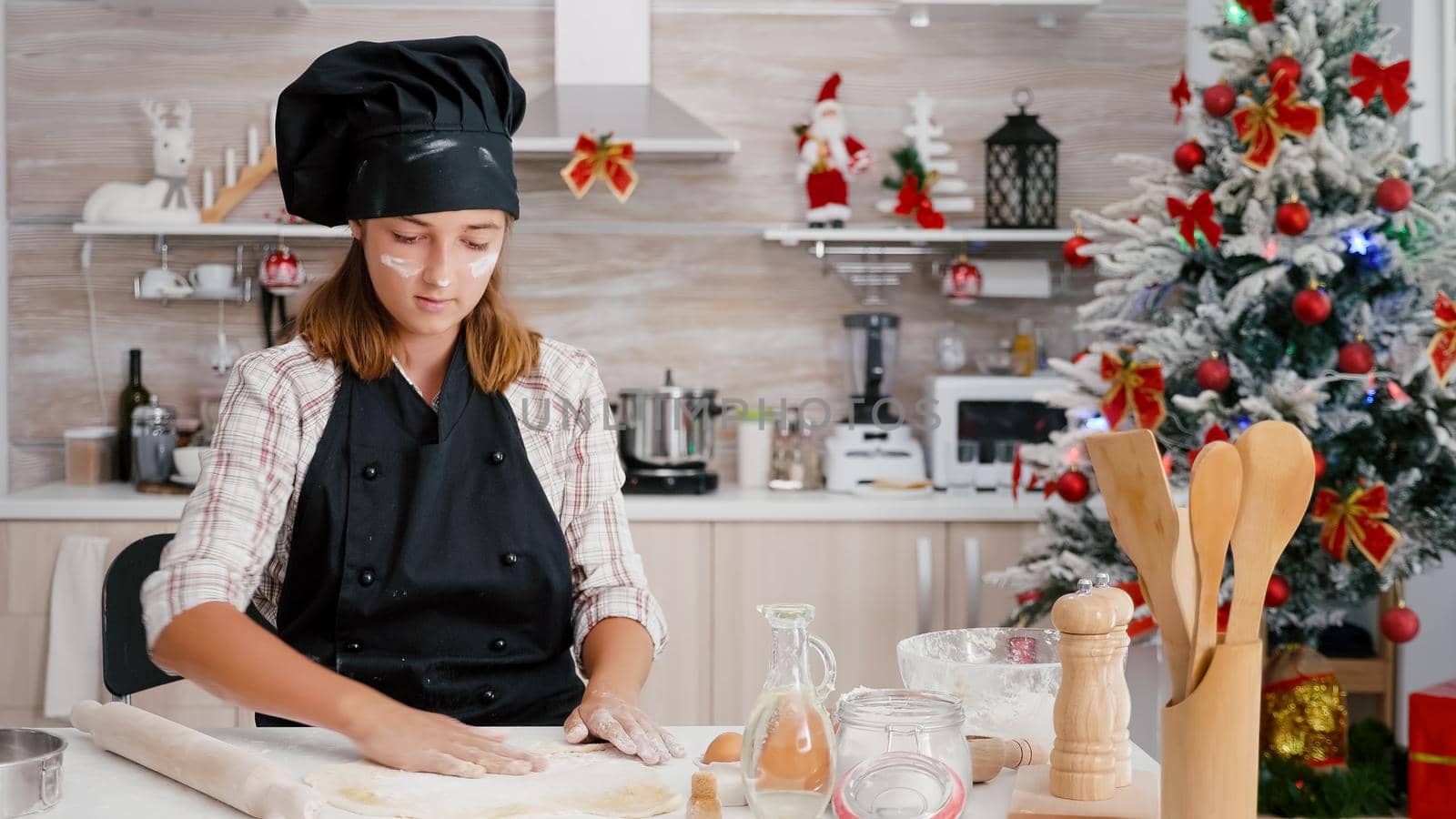 Portrait of children putting flour ingredient on homemade gingerbread dough using cooking rolling pin enjoying baking dessert. Granddaughter celebrating christmas holiday in culinary kitchen