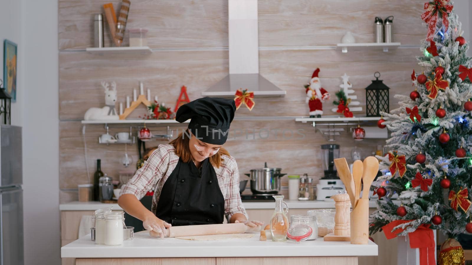 Portrait of happy child wearing apron making homemade dough using rollling pin by DCStudio