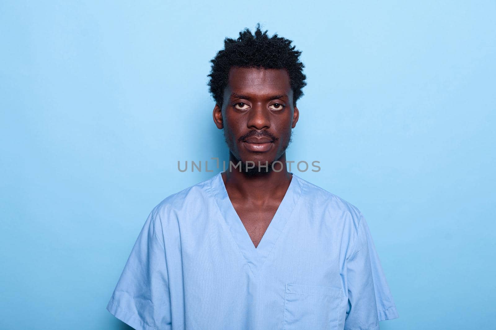 Portrait of black man nurse standing over blue background by DCStudio