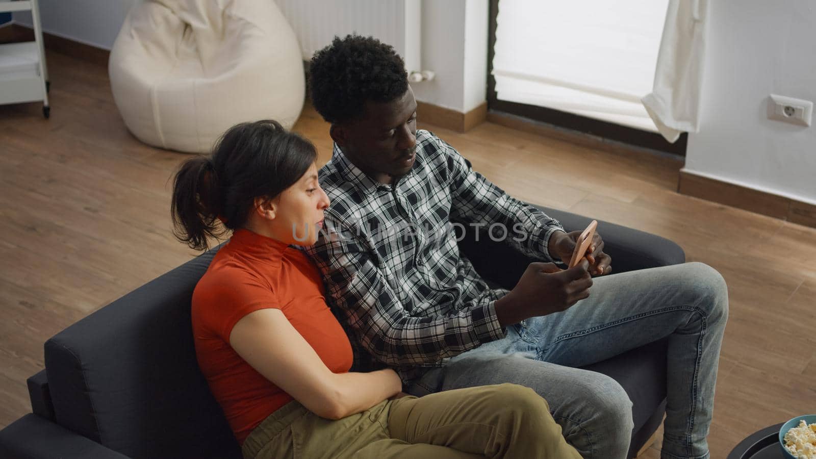 Married interracial couple taking selfie with smartphone by DCStudio