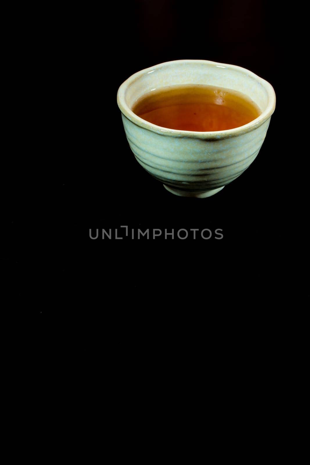 Tea in ceramic cup on black background