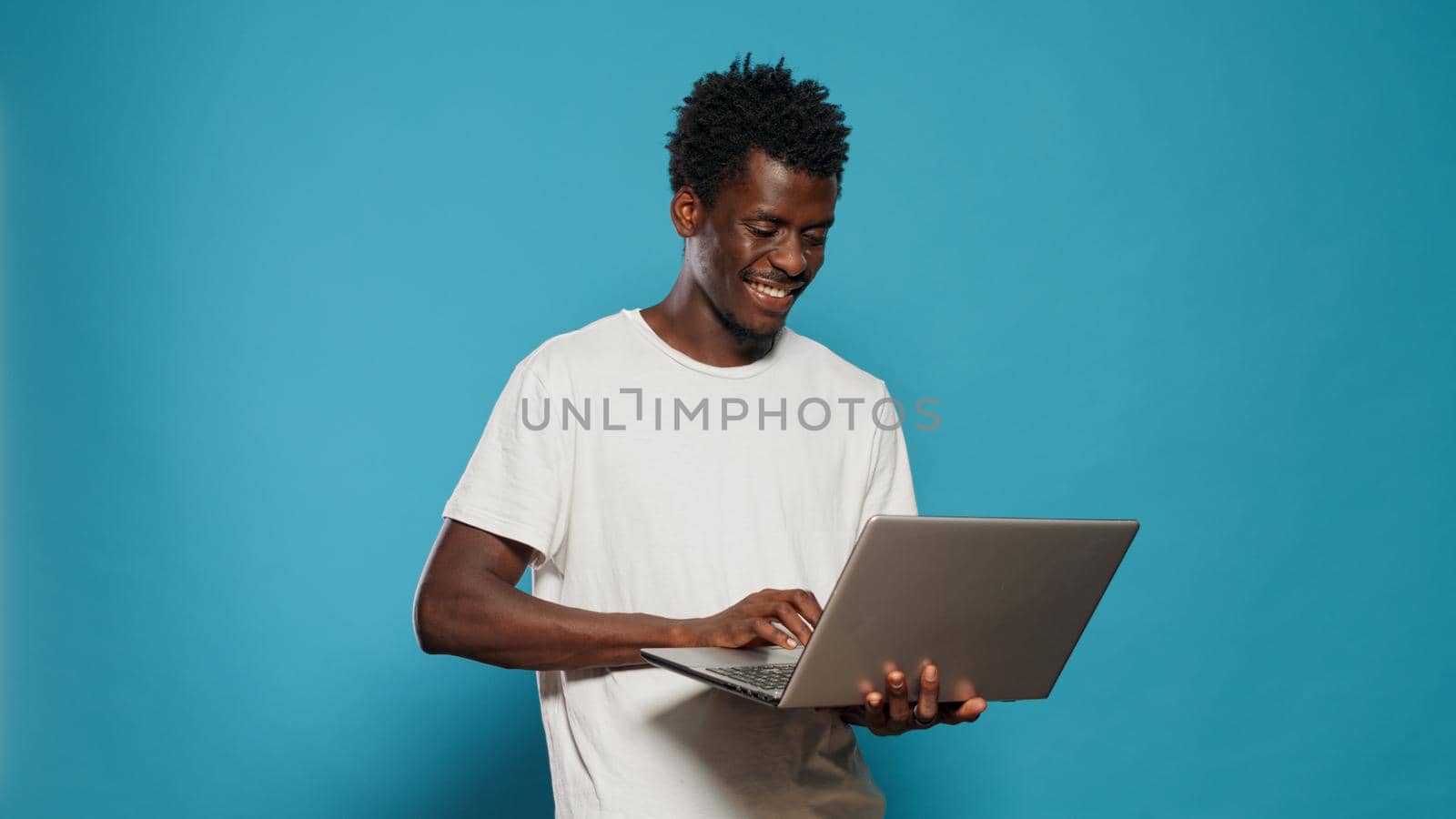 African american man using laptop for entertainment by DCStudio