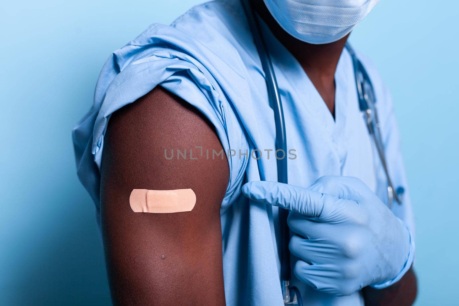 Close up of bandaged vaccine shot on arm of man nurse by DCStudio