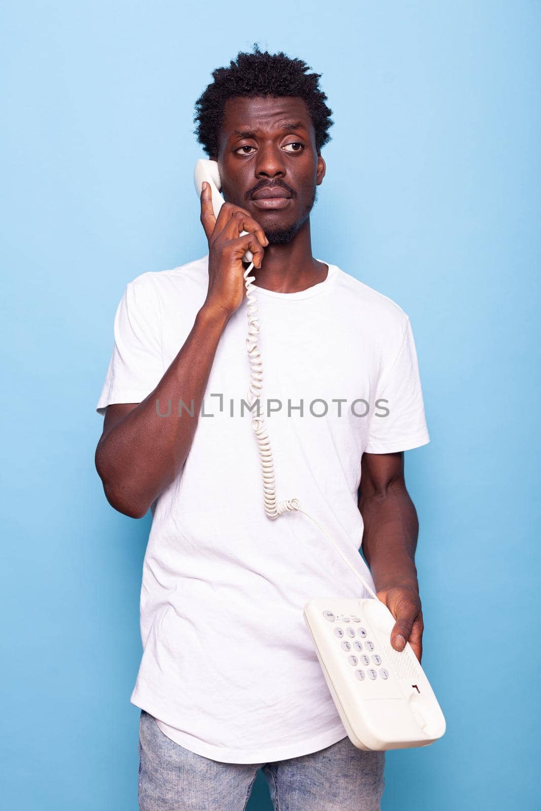 Young adult answering retro telephone with wire by DCStudio