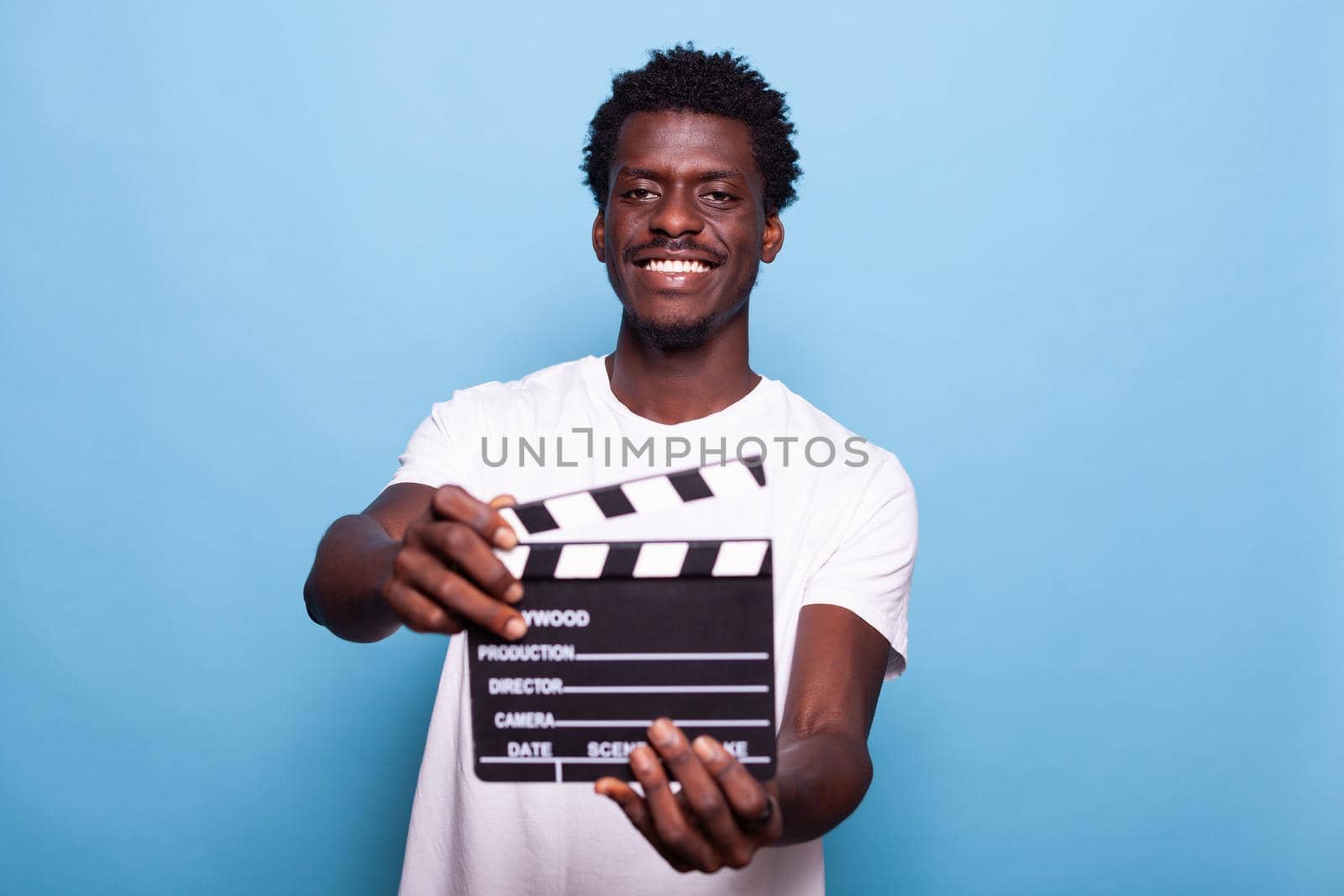 Portrait of man holding clapperboard to cut scenes by DCStudio