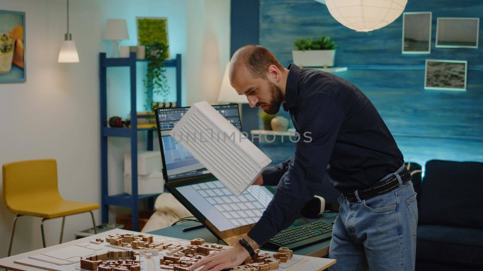 Young engineer holding maquette model analyzing layout by DCStudio