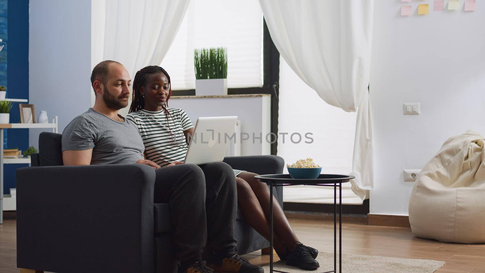 Interracial couple using video call communication at home by DCStudio