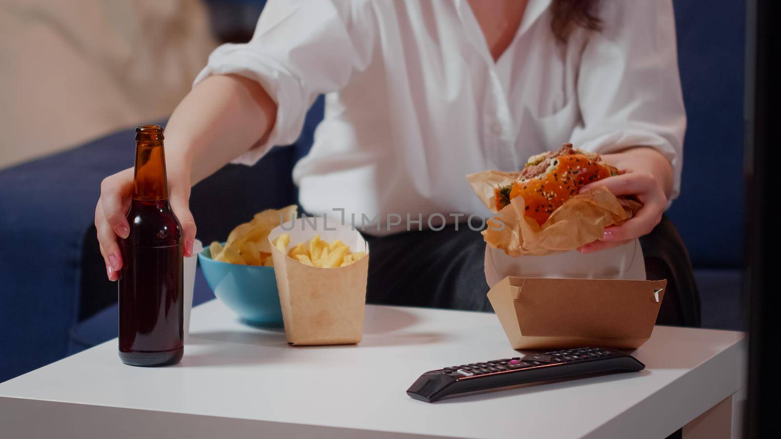 Close up of table with delivery fast food and person eating by DCStudio