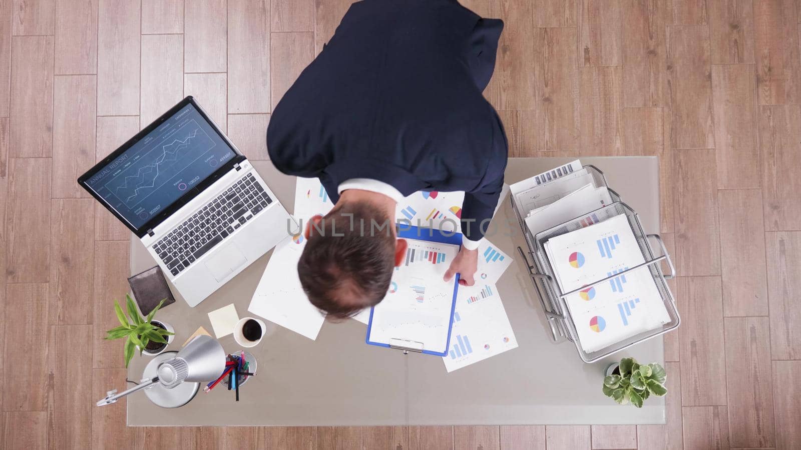 Top view of successful businessman analyzing financial documents by DCStudio