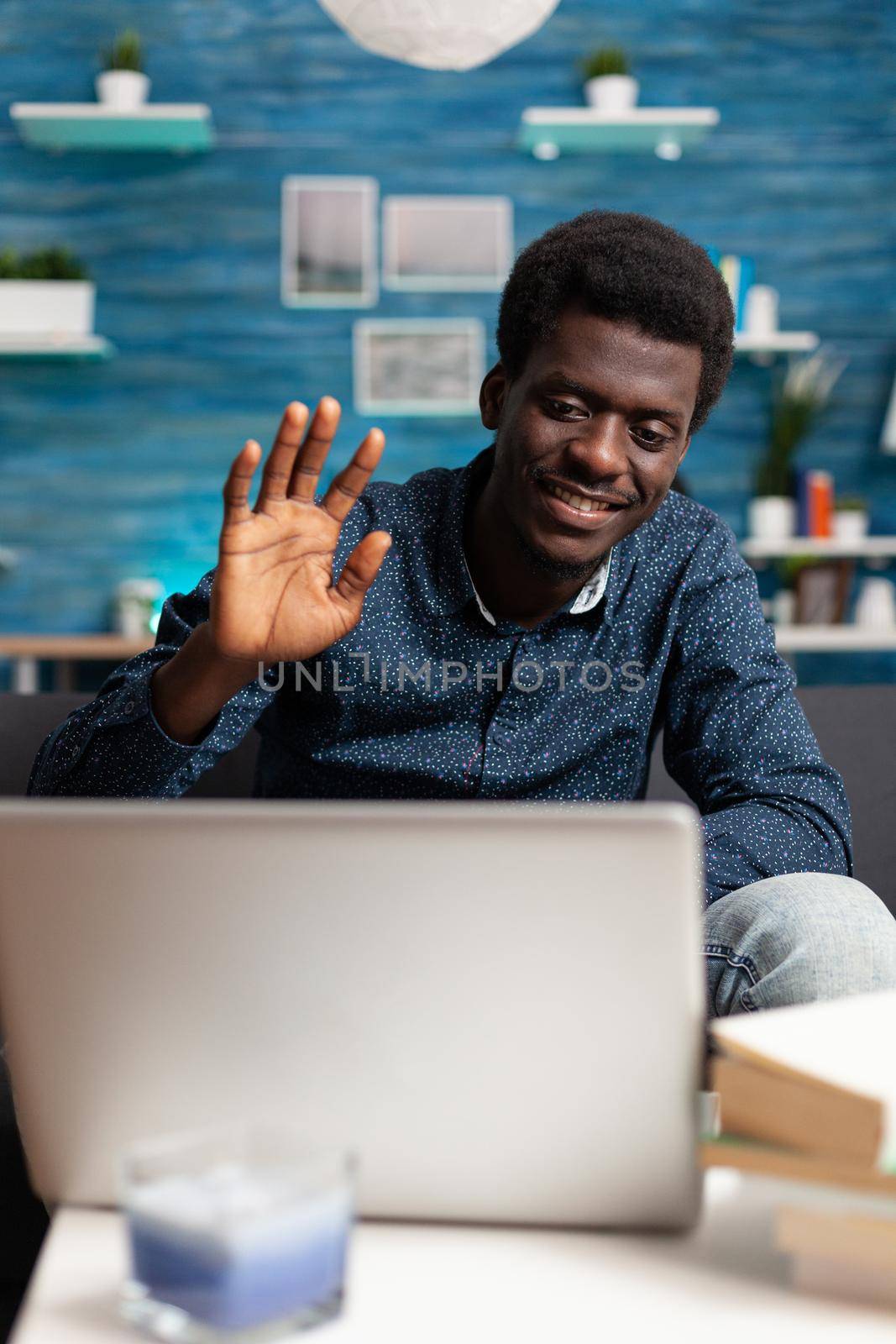 African american entrepreneur on remote video call from his living room, talking to workmates using online internet conference communication technology. Black working from home person