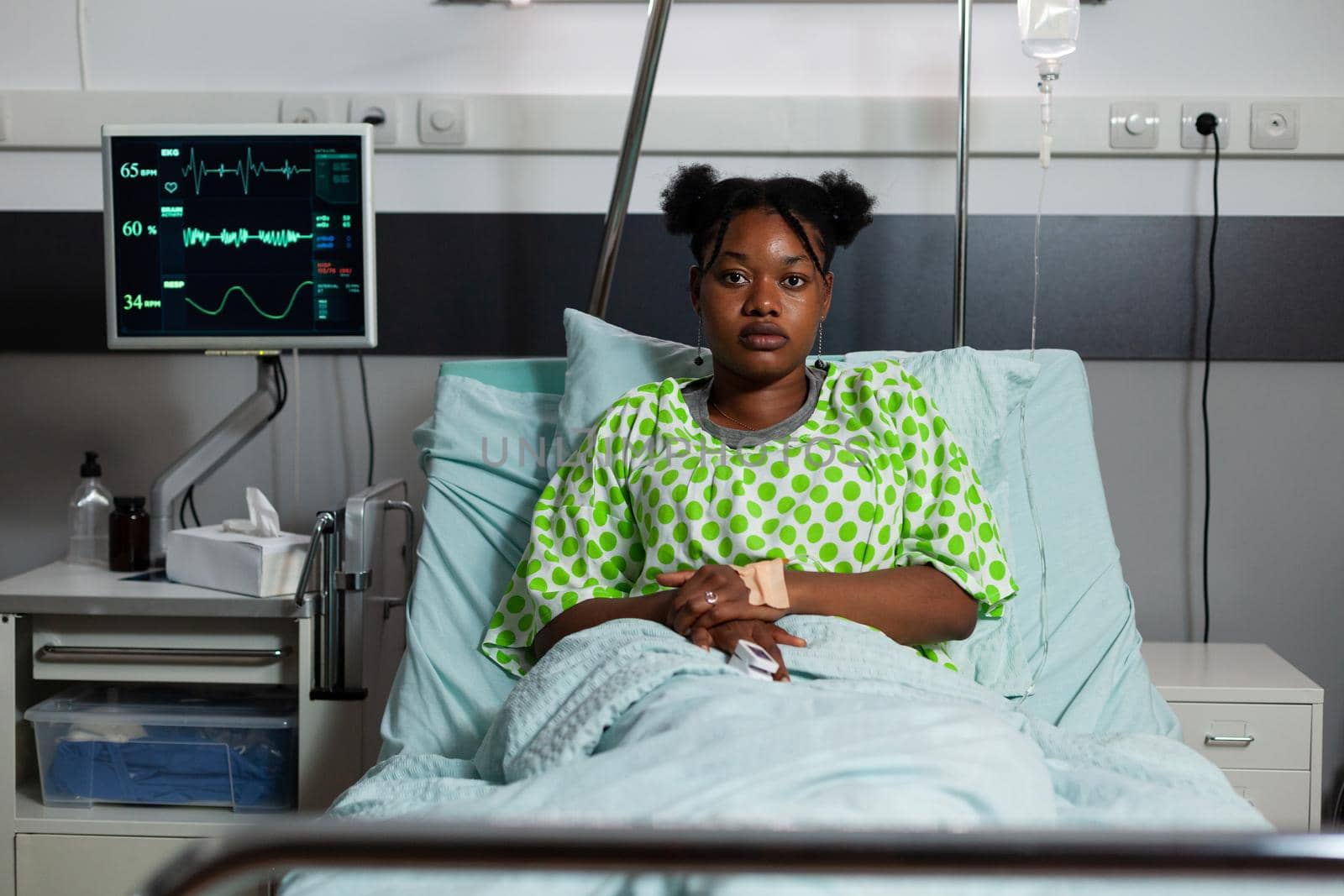 Portrait of african american girl sitting in hospital ward by DCStudio