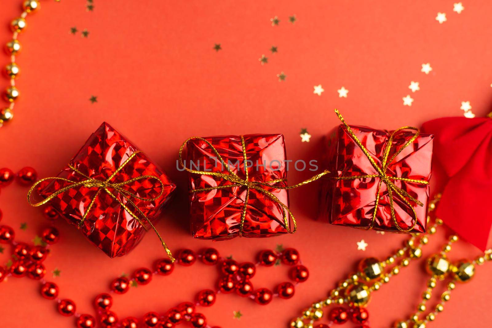 Red Christmas gifts and Christmas trees on a red background. An article about the New year and Christmas. The choice of gifts. A red gift . New Year's background