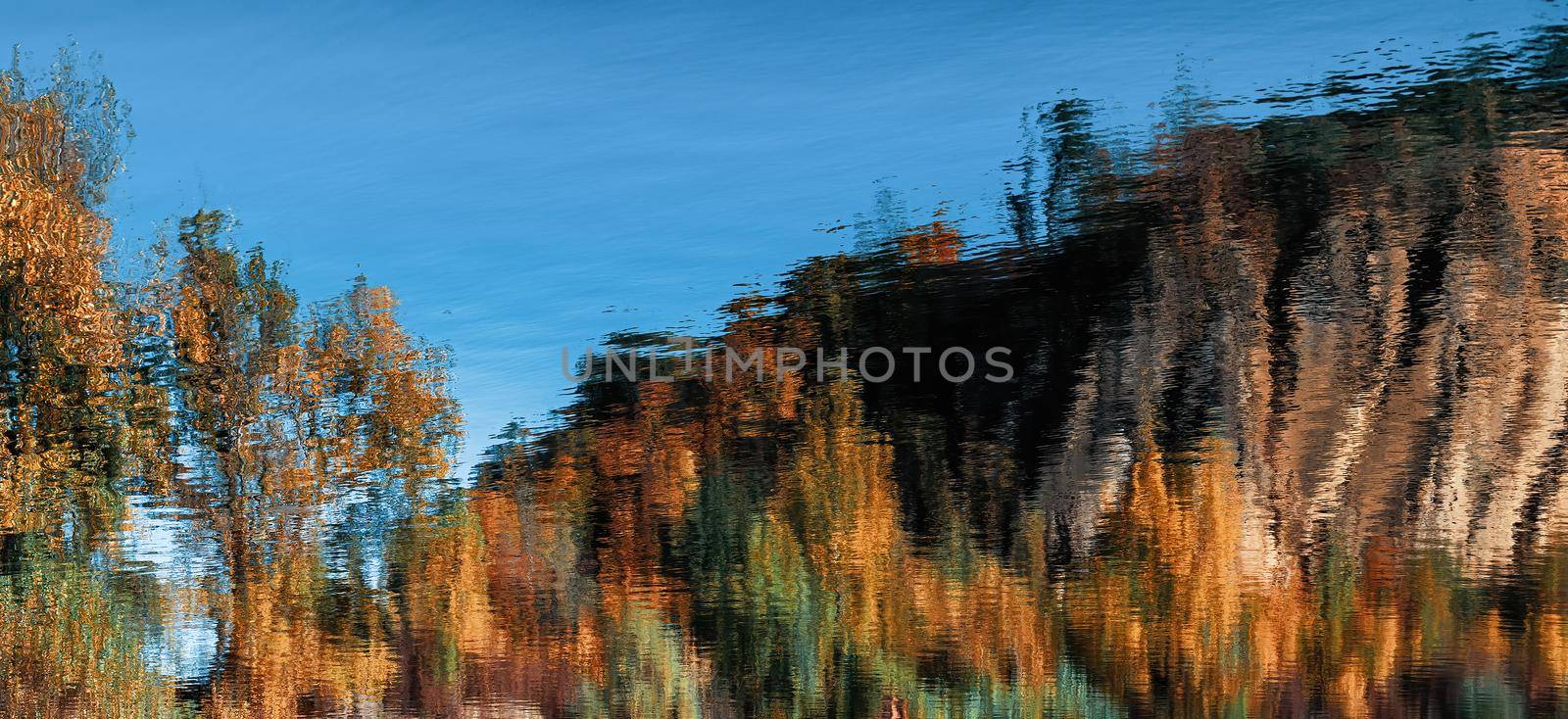 Abstract natural background. Reflection of an autumn forest in the water of a mountain lake