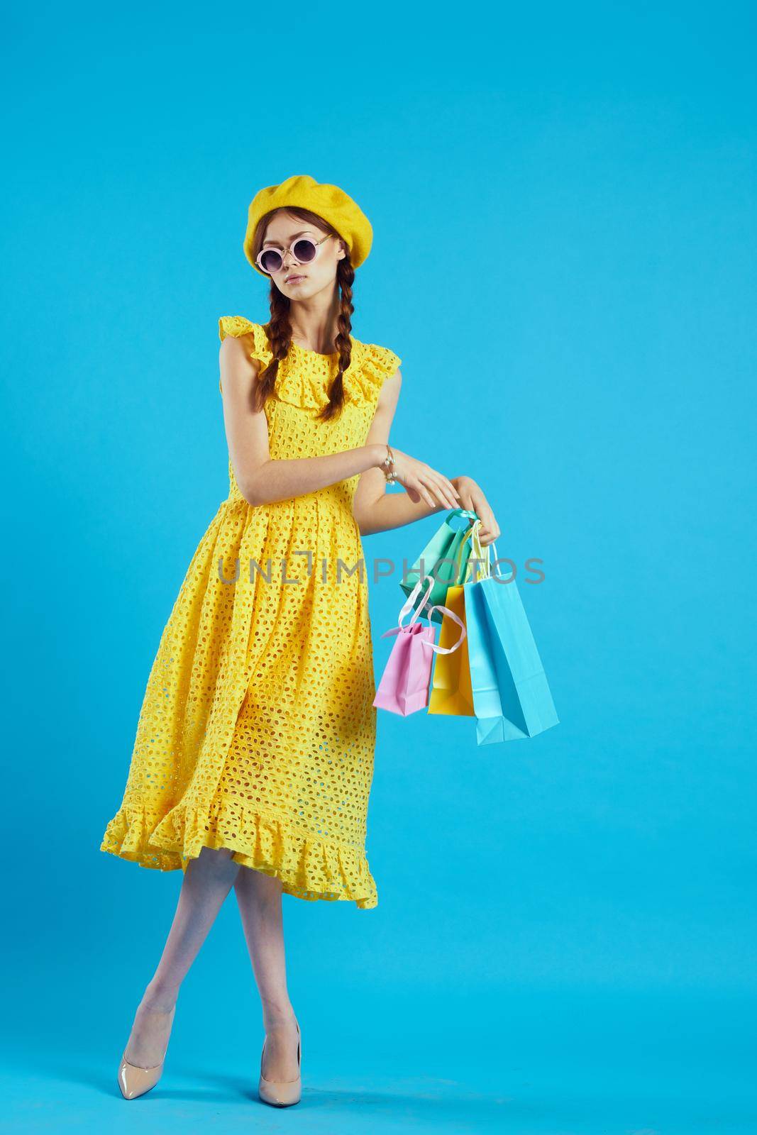 cheerful woman in a yellow hat Shopaholic fashion style studio model by Vichizh