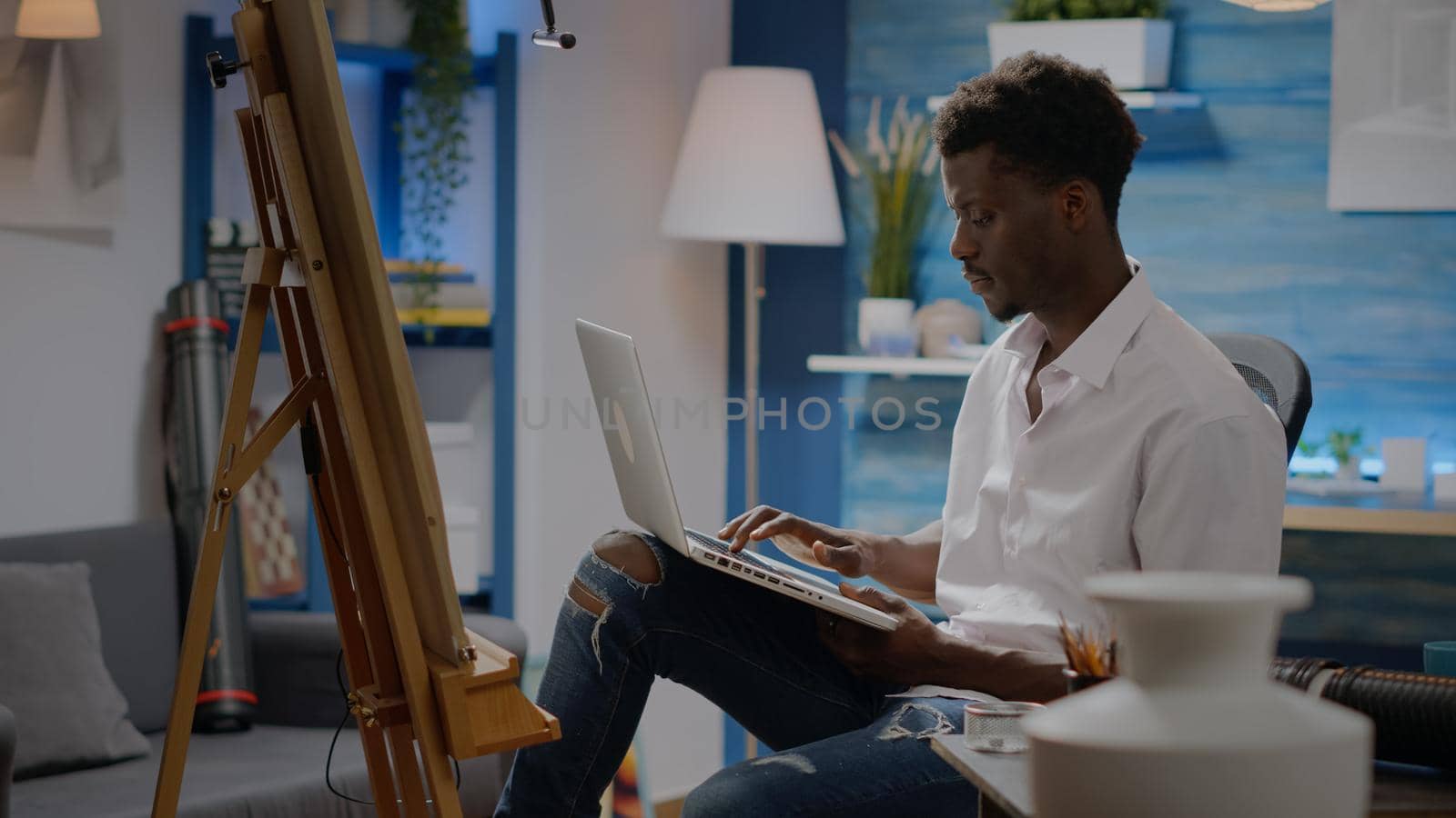 Black young artist using laptop technology for art concept by DCStudio