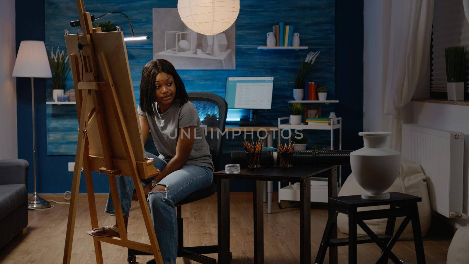 Adult of african american ethnicity working on fine art concept in artwork studio room at home. Black young artist designing drawing of vase for next successful masterpiece project