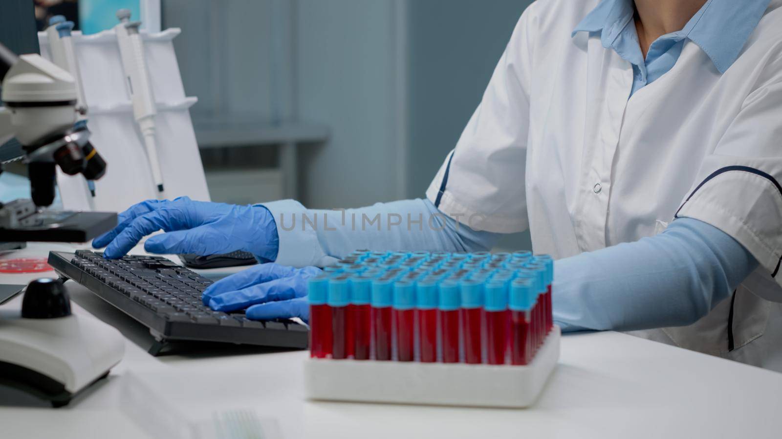 Scientific doctor analyzing sample of blood from vacutainer in laboratory. Specialist woman using flask with liquid for genetic testing. Chemical glassware in lab science industry