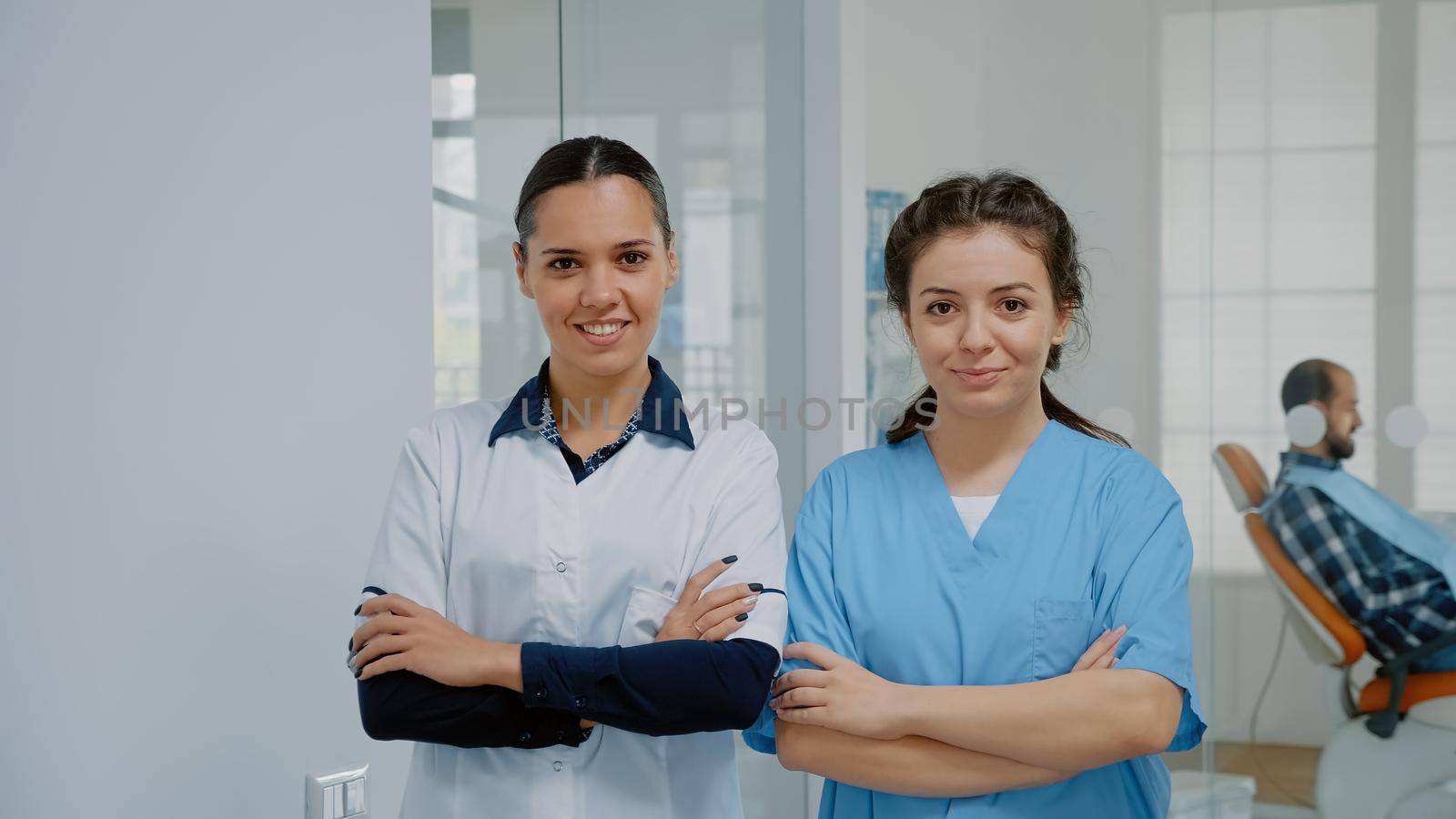 Dentist and nurse in medical uniform standing at dental clinic by DCStudio