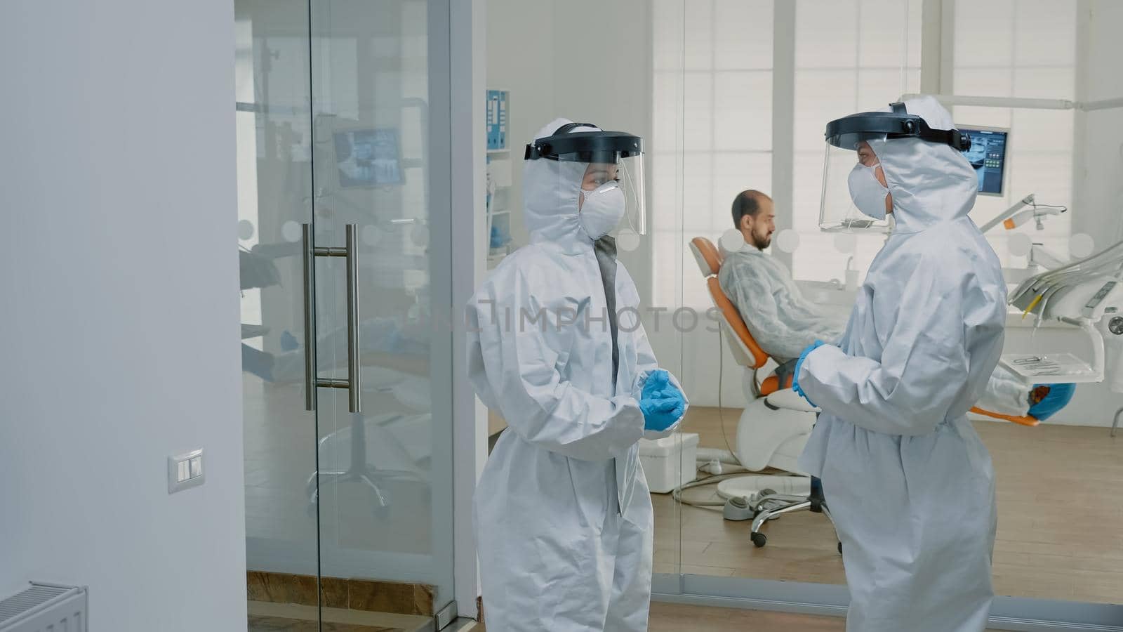 Stomatological doctors wearing ppe suits at dental clinic by DCStudio