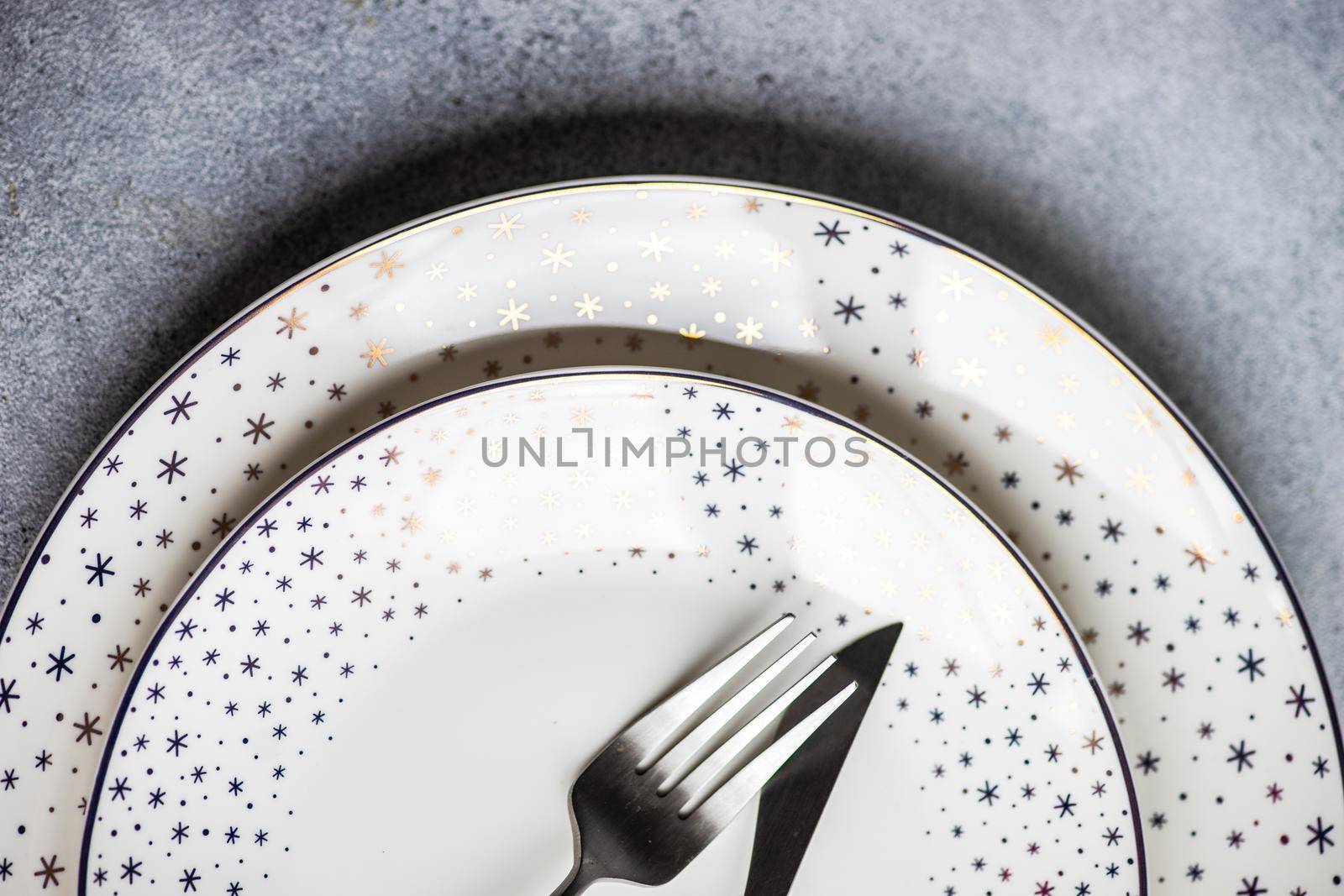 Minimalistic table setting for Christmas dinner on white concrete table