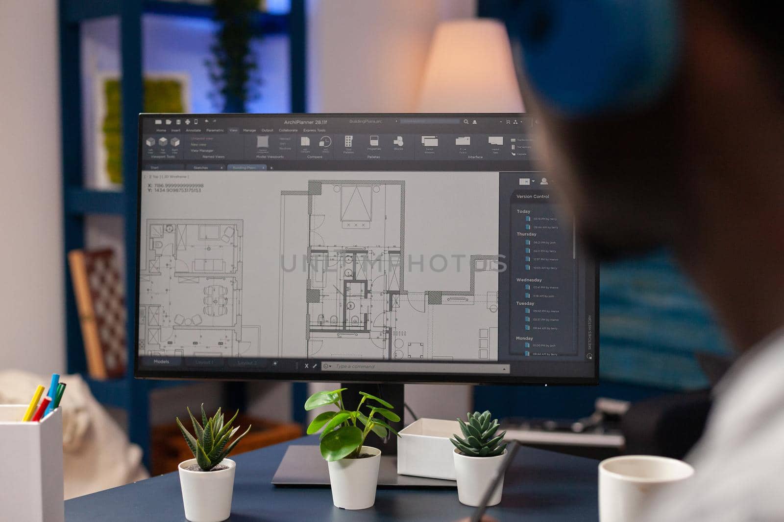 African american architect man with headphones analyzing construction model plan developing skyscraper building sketch. Young engineer working remote from home at developing architecture building