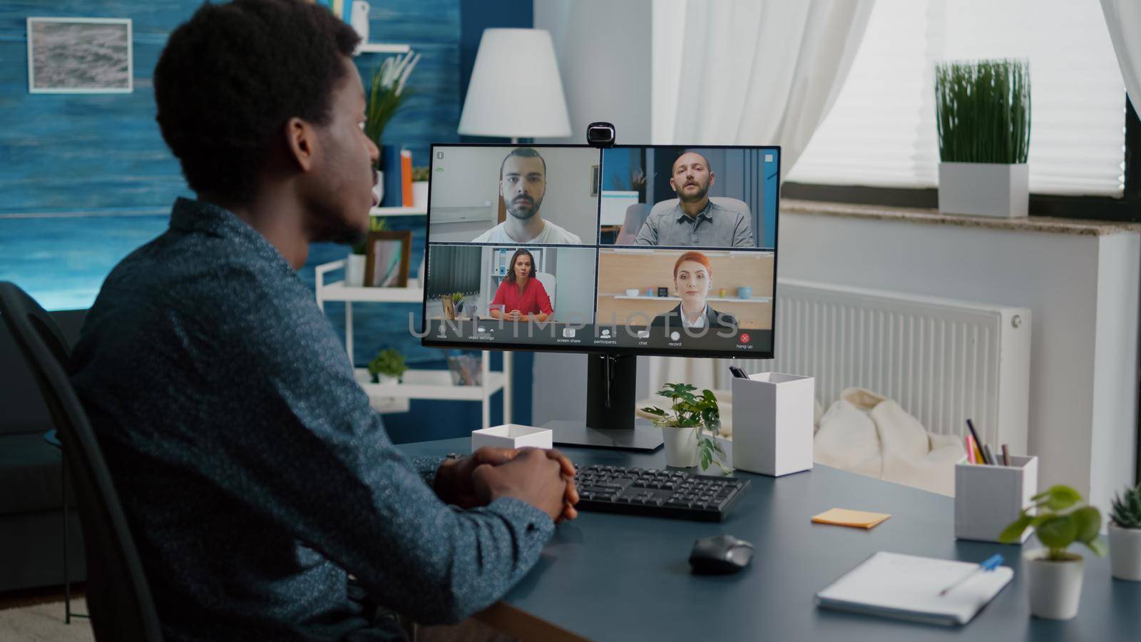 Black man on online internet conference chat with his coworkers by DCStudio