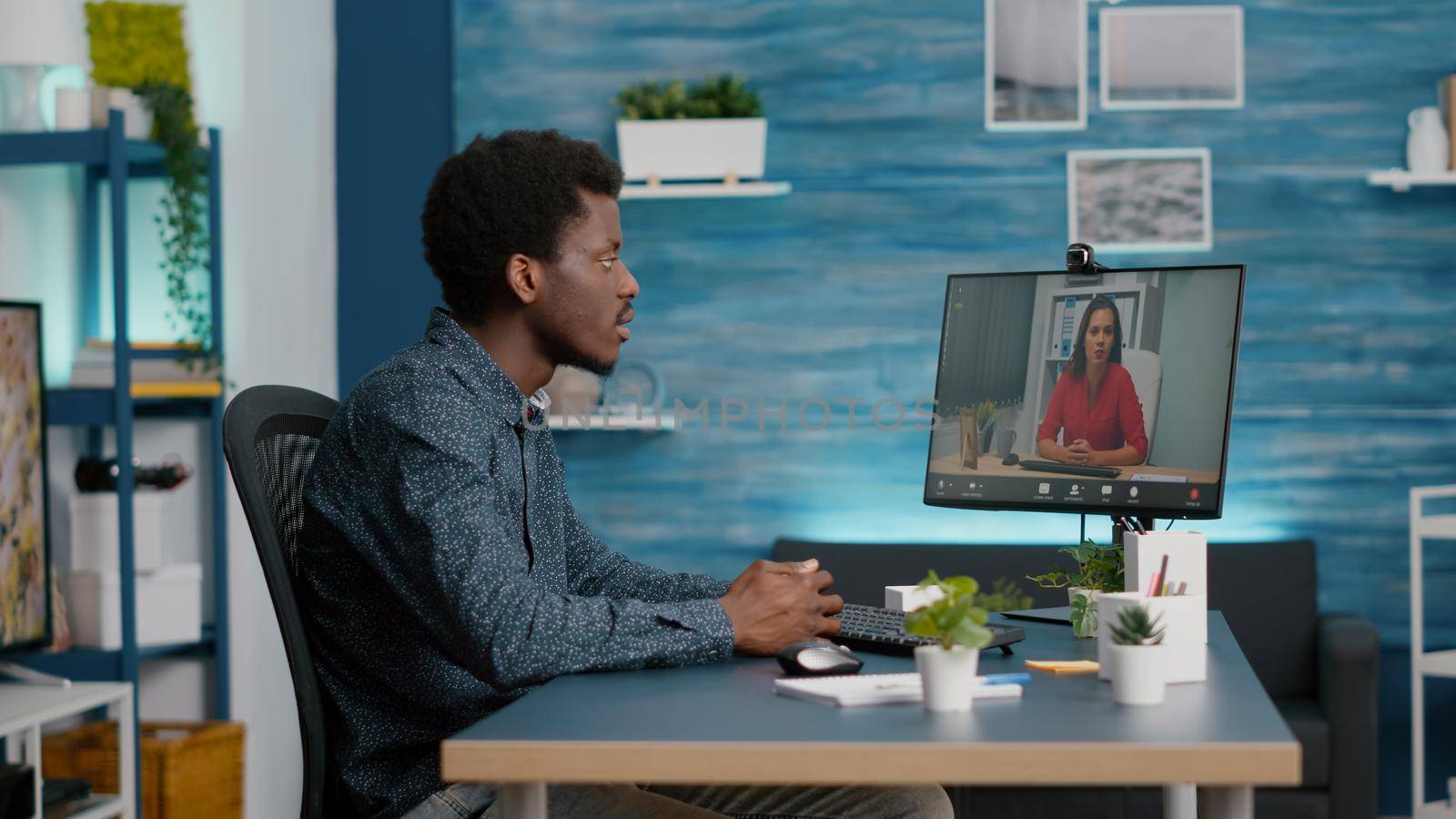 Remote worker working from home, talking on online conference internet video call with woman coworker. African american man on web teleconference, using computer webcam as communication device