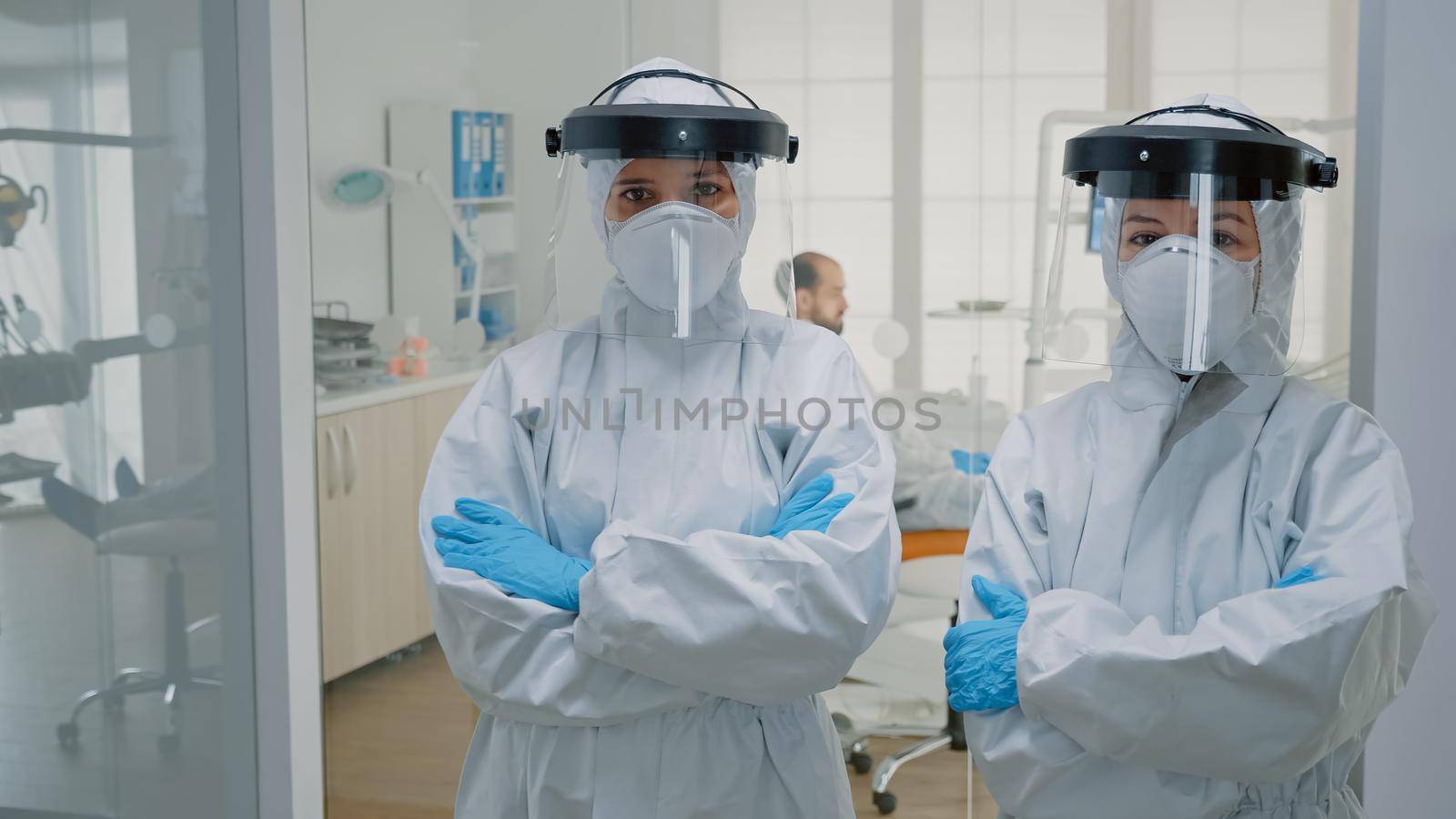 Professional team of dentists in ppe suits standing by DCStudio